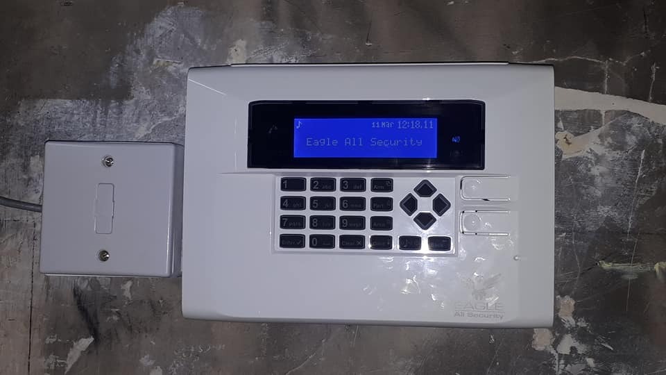 Eagle All Security branded alarm panel with LCD display showing company name