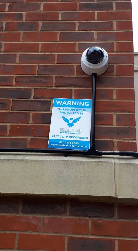 CCTV warning sign and dome camera installed at a North London property