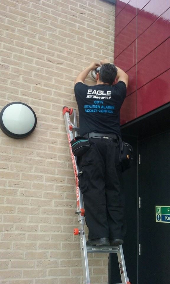 Eagle All Security engineer installing CCTV camera wearing branded uniform